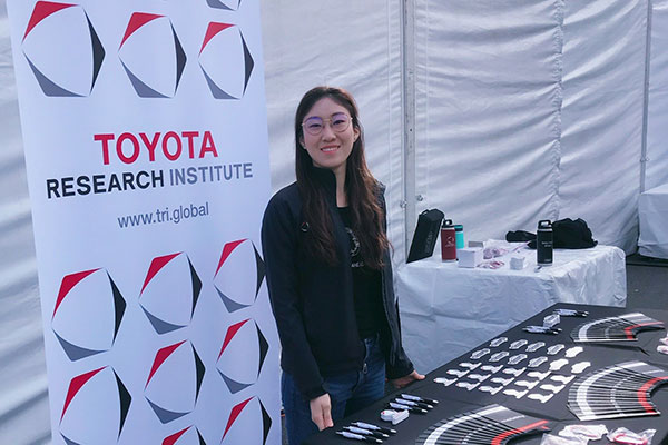 student working at Toyota Research Institute manning a table at a fair