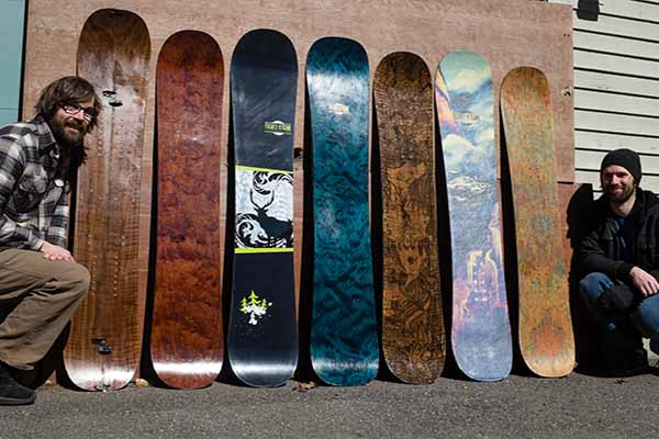 skateboards lined up along wall with two founders on each end