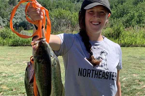student holding up a few fish she caught