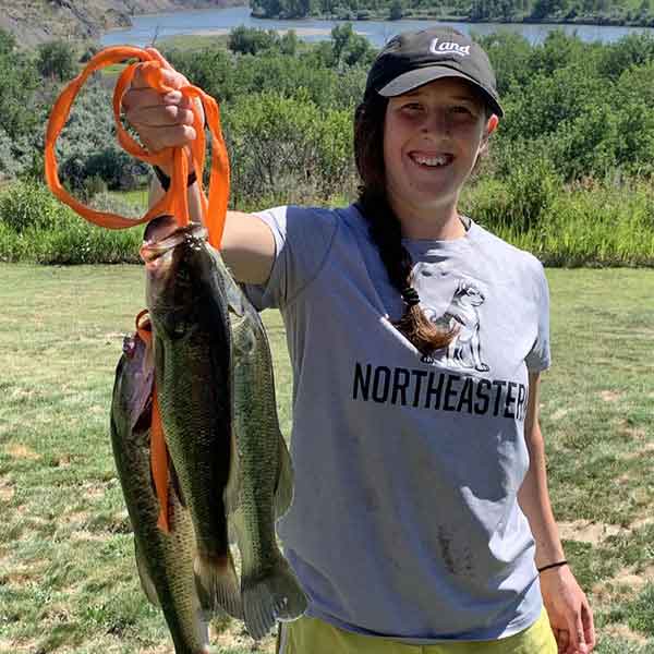 student holding up a few fish she caught
