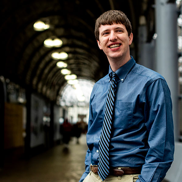 photo of student in subway area with train in background
