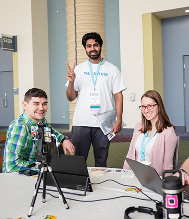Subash Rajaseelan at a tech conference with two other presenters