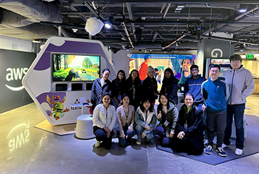 A group of 13 people stand together posing for a picture