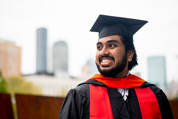 student in graduation attire smiling