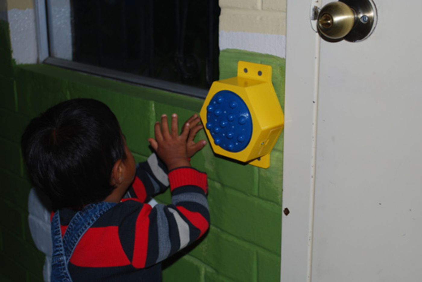 A kid at the For His Children Orphanage uses the communication button.